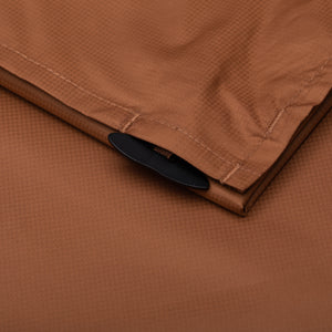 corner stake was put in its pouch on the dark brown picnic blanket.
